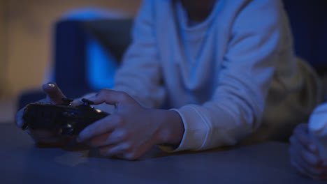 Close-Up-Of-Two-Young-Boys-At-Home-Playing-With-Computer-Games-Console-On-TV-Holding-Controllers-Late-At-Night-7